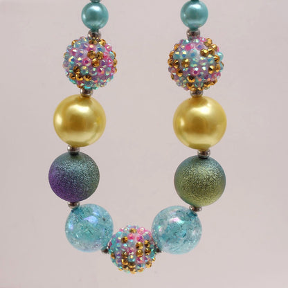 Close-up of aqua gold and purple acrylic beaded dog necklace with sparkle beads