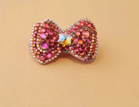 Pink rhinestone bow pet hair accessory with iridescent crystal butterfly centerpiece