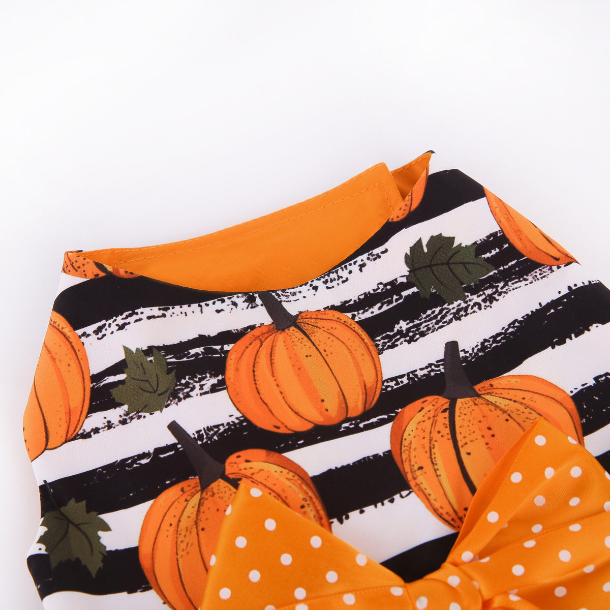 Close-up of pumpkin print bodice and orange bow on the Halloween pet dress