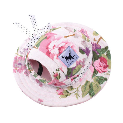 Pink floral pet sun hat with ear holes and polka dot bow on white background