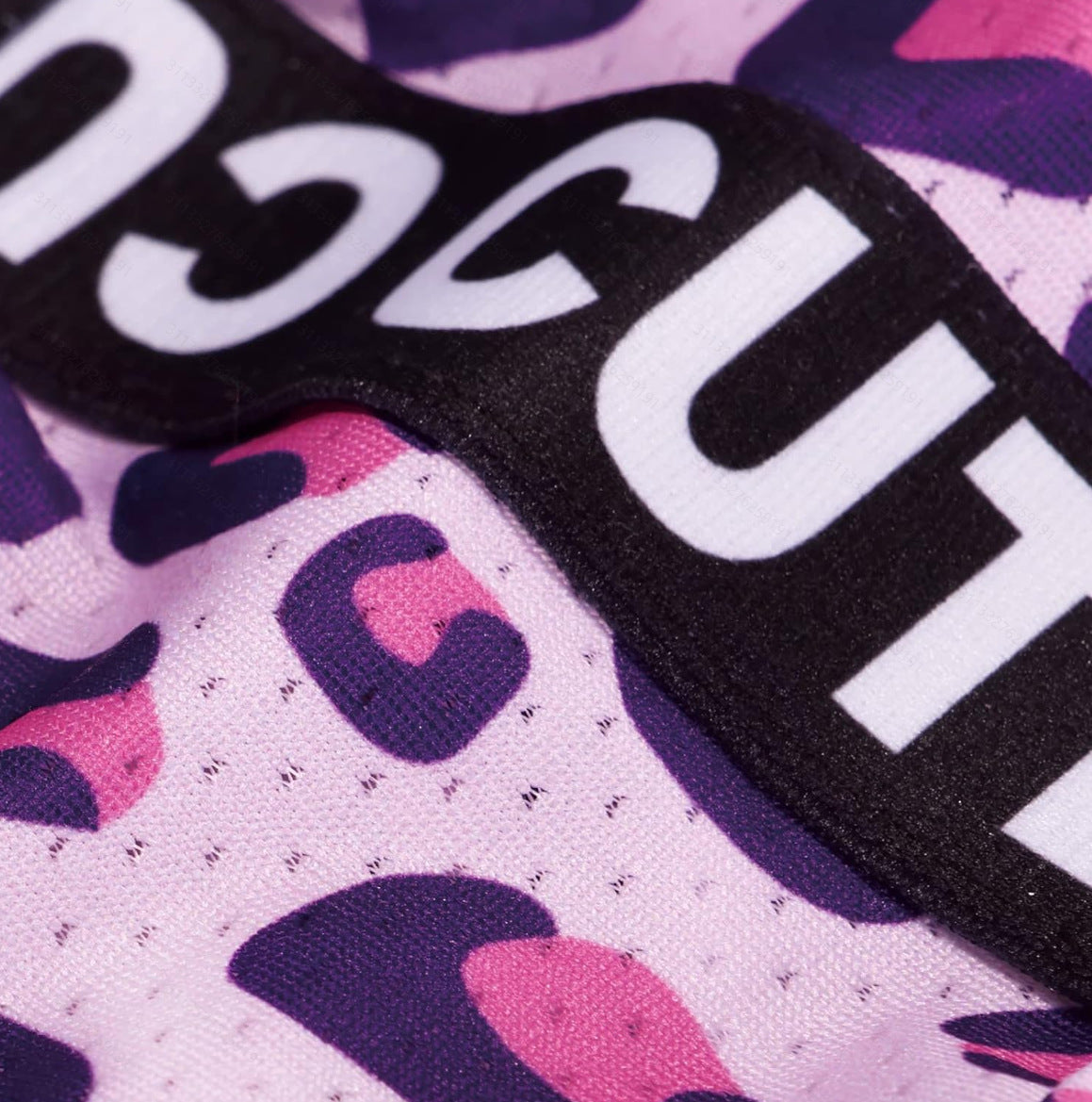 Close-up of the pink leopard print fabric and black CUTE band on the dog dress