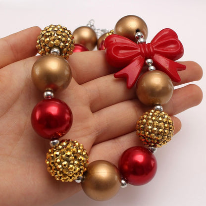 Hand-held close-up of red gold bow acrylic bead pet necklace