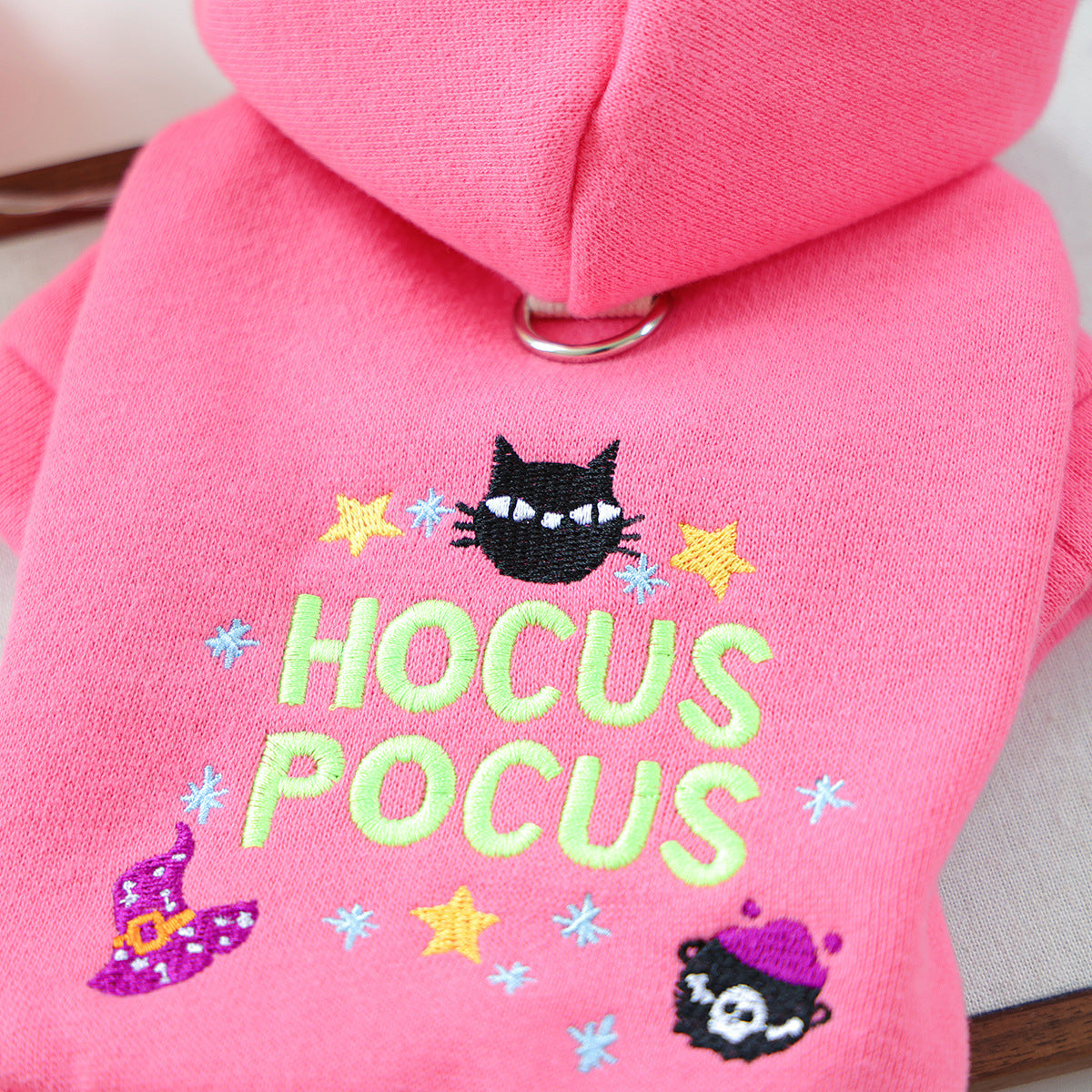Close-up of black cat witch hat stars and Hocus Pocus embroidery on pink pet hoodie