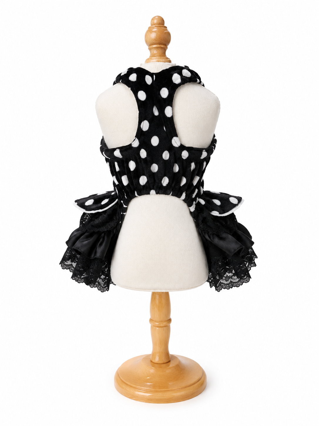 Back view of black polka dot pet dress with lace skirt and open-back design on mannequin