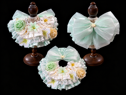 Green floral pet bib collar display showing front and back views on stands
