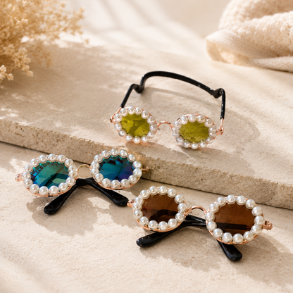 Gold, gradient, and brown pearl round pet sunglasses arranged on stone