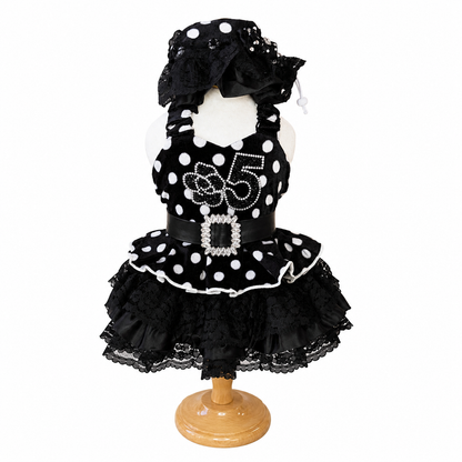 Front view of black polka dot pet dress with rhinestone-style buckle, lace ruffles, and matching bonnet