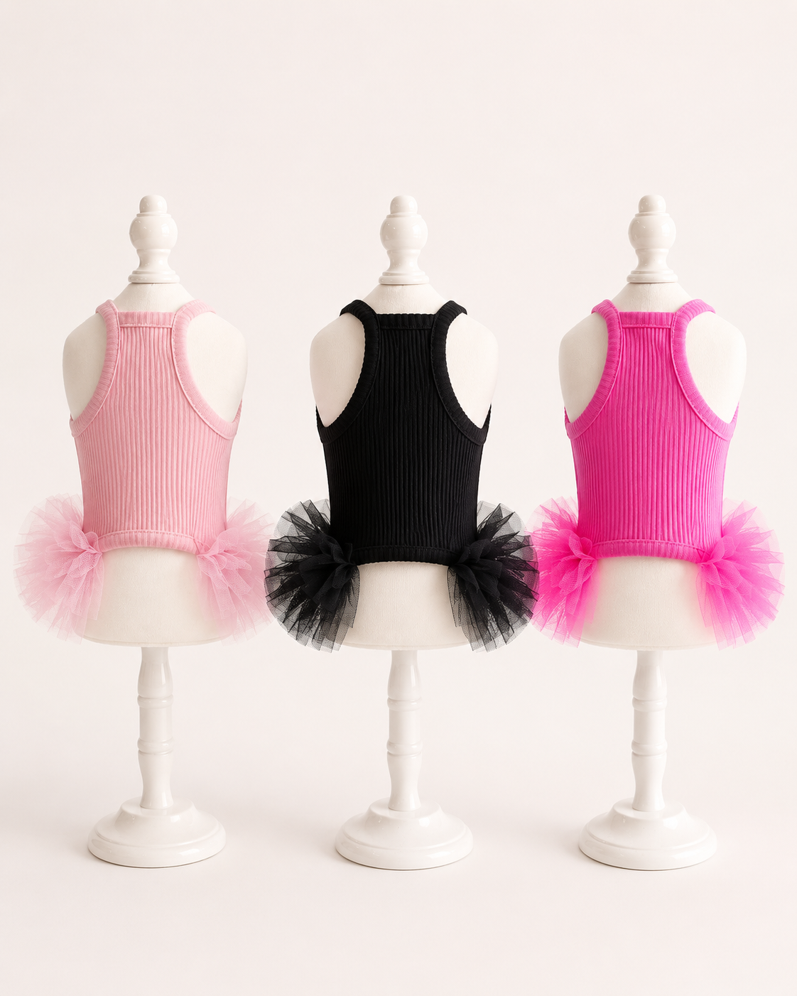 Back view of pet tutu dresses in blush pink black and hot pink showing racerback design