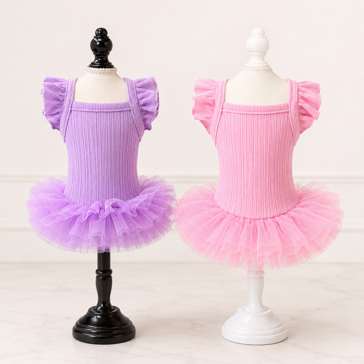 Pink and lavender flutter sleeve dog tutu dresses displayed on boutique mannequins